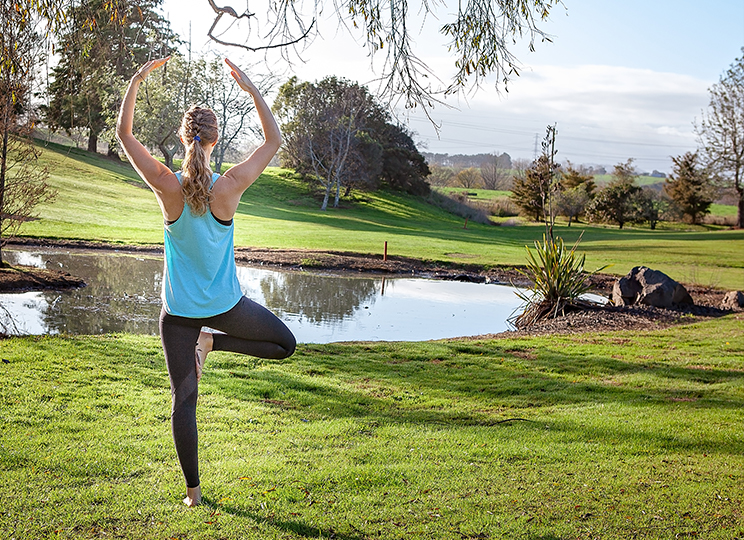 maria in yoga pose with pond backdrop